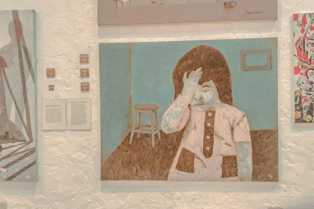 Painting of girl with hand on face, a Filipino contemporary painting inside one of the galleries at Pinto Art Museum in Antipolo
