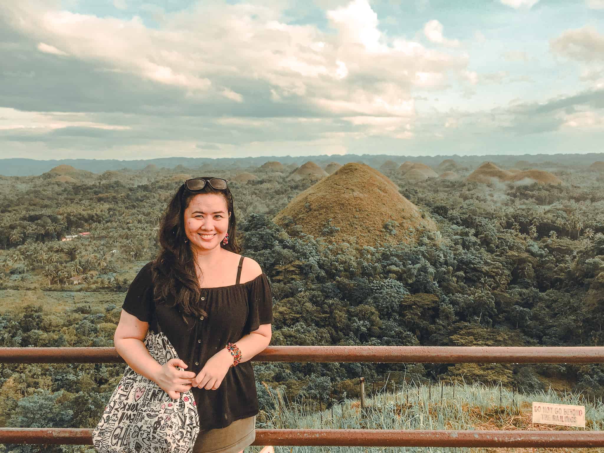 The Boho Travels, a blogger, visiting Chocolate Hills, Bohol, Philippines. One of the reasons why the answer is YES to the question, "is the Philippines worth visiting?"