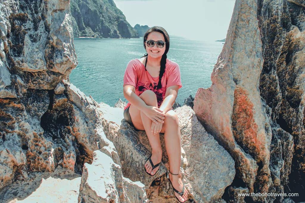 A woman in pink in Matinloc Shrine hoping to answer the question, is El Nido worth visiting?