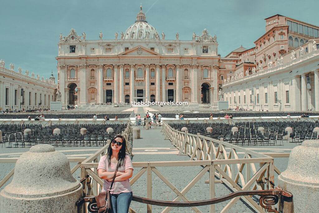 A woman traveler posing in front of St. Peter's Basilica at the Vatican City, a must-visit even if you only have one day in Rome.