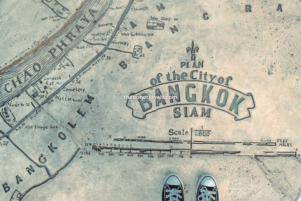 Foot photo of The Boho Travels on top of plan of the City of Bangkok, found on the floor of Asiatique
