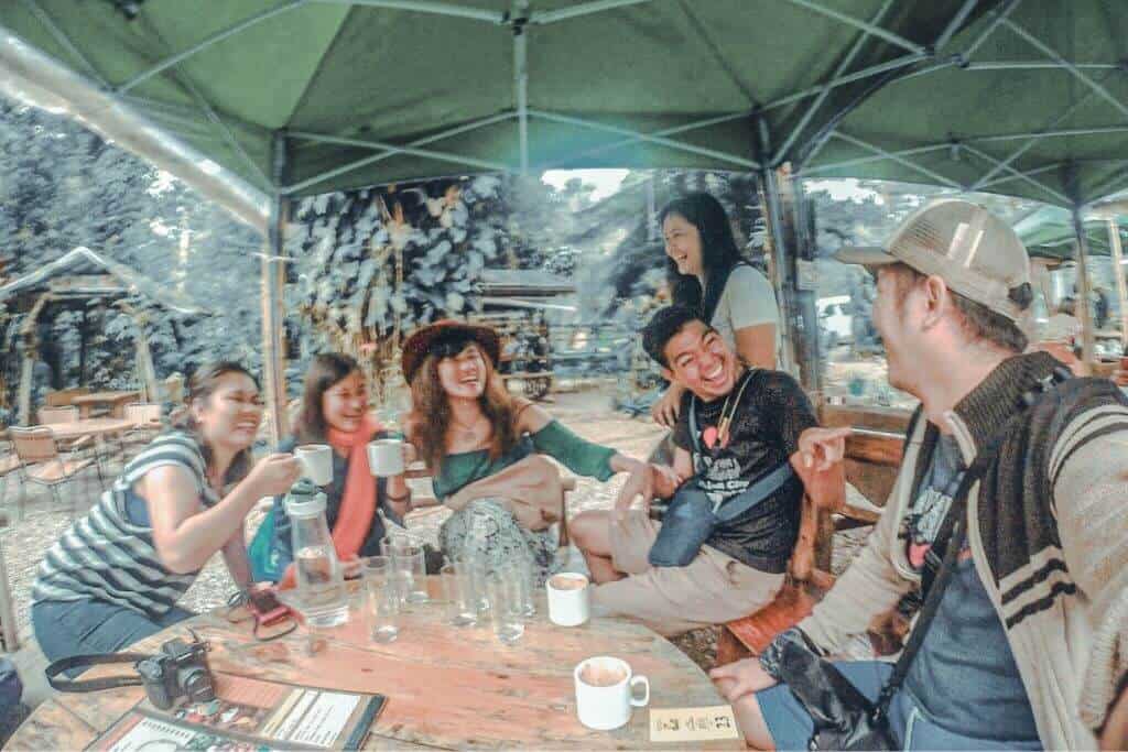 A group of friends enjoying their own cup of hot chocolate at Choco-late de Batirol in Camp John Hay, one of the must-try places to eat in Baguio, especially for first-time visitors.